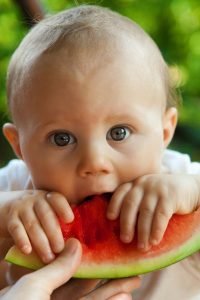 Un bebé comiendo un trozo de sandia - Tambien se pude hacer zumo con ella